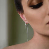 Close-up of side of Woman's face Wearing Sterling Silver Aurora Statement Earrings with hoop top and dainty hanging chain jewellery 